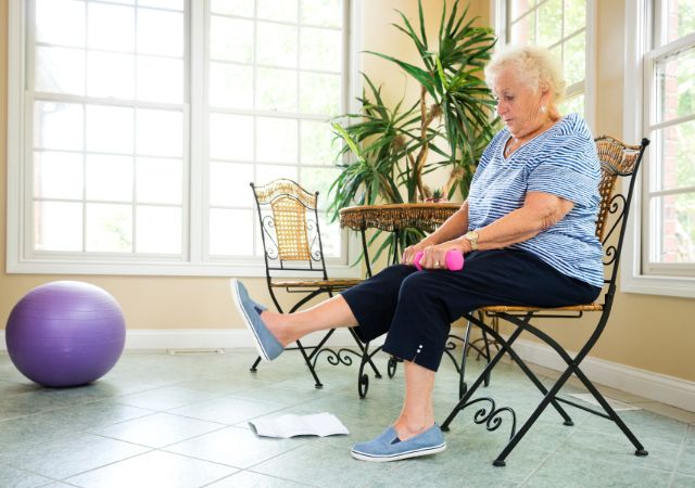 senior woman performing exercises seated on a chair