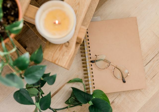 Image of a notebook, candle and houseplant