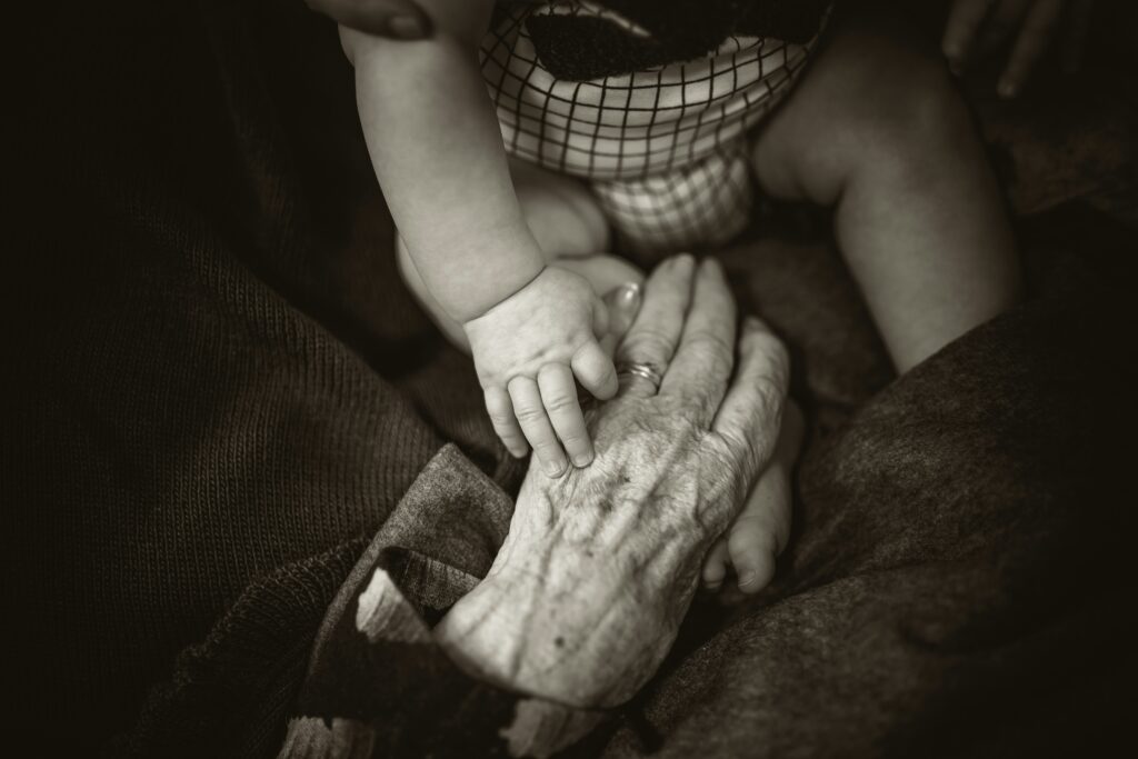 baby hand holding senior old hand